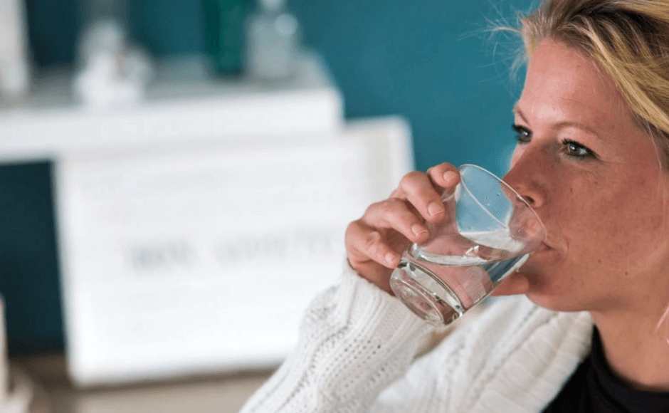 Frau trinkt ein Glas Wasser