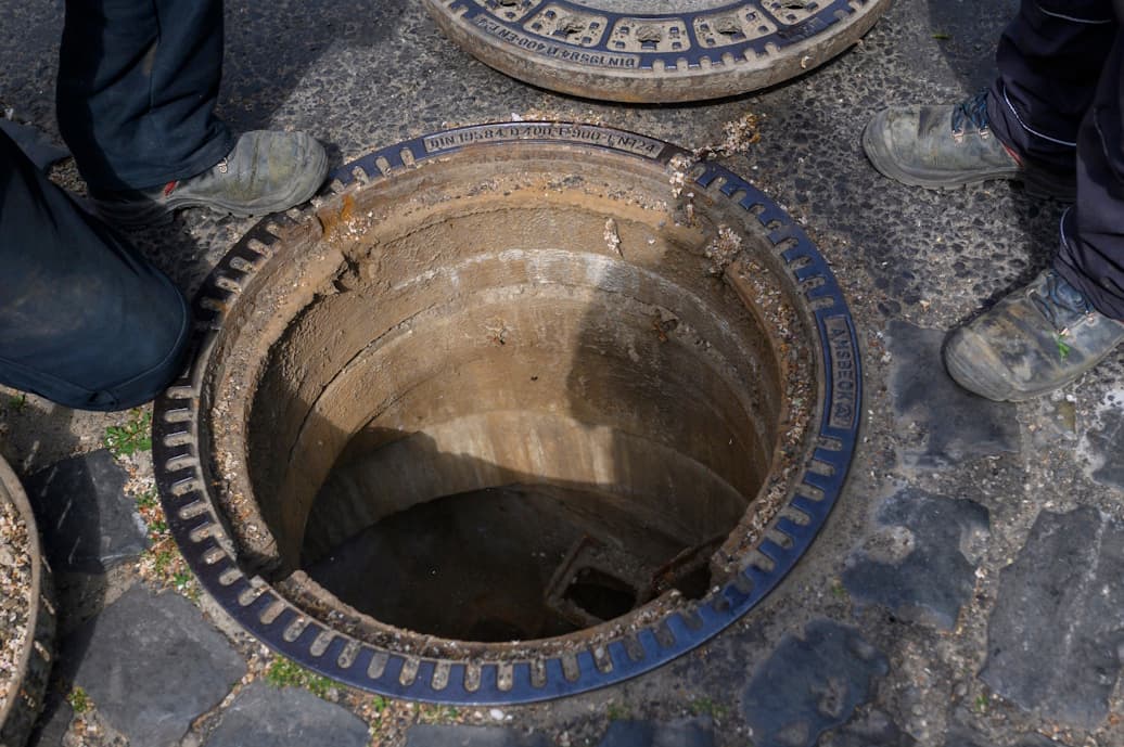 Blick auf einen geöffneten Straßengully.