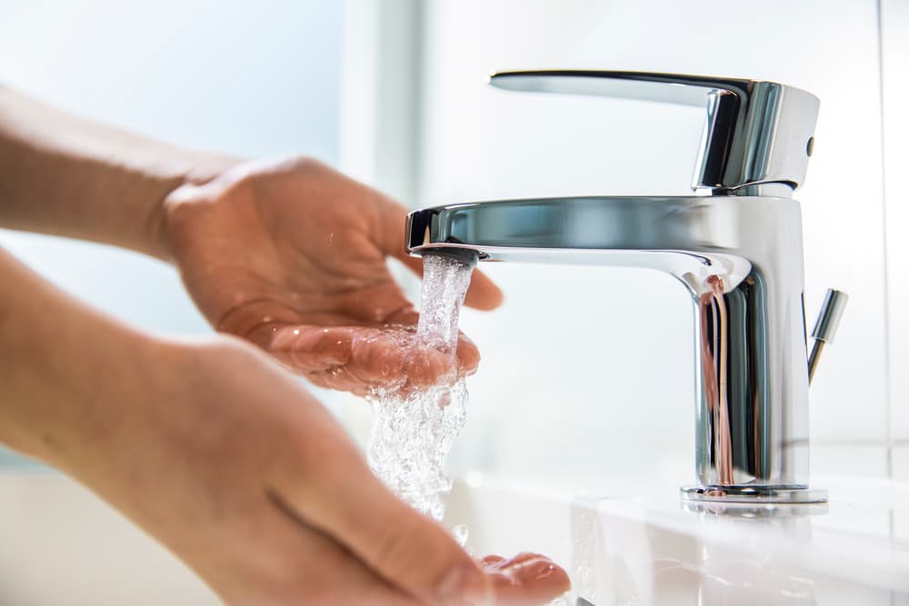 Händewaschen mit frischem Trinkwasser unter einem Wasserhahn.