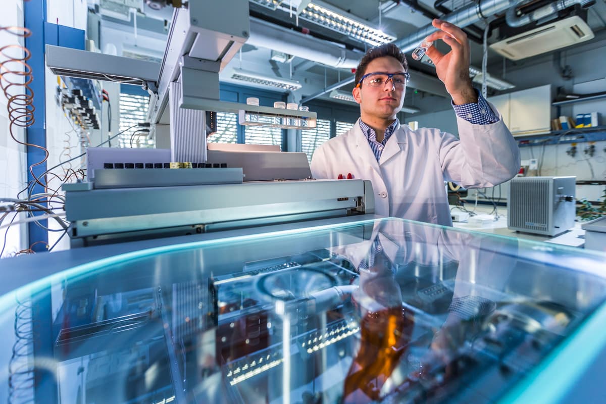 Laborant prüft Laborprobe im Reagenzgläschen.