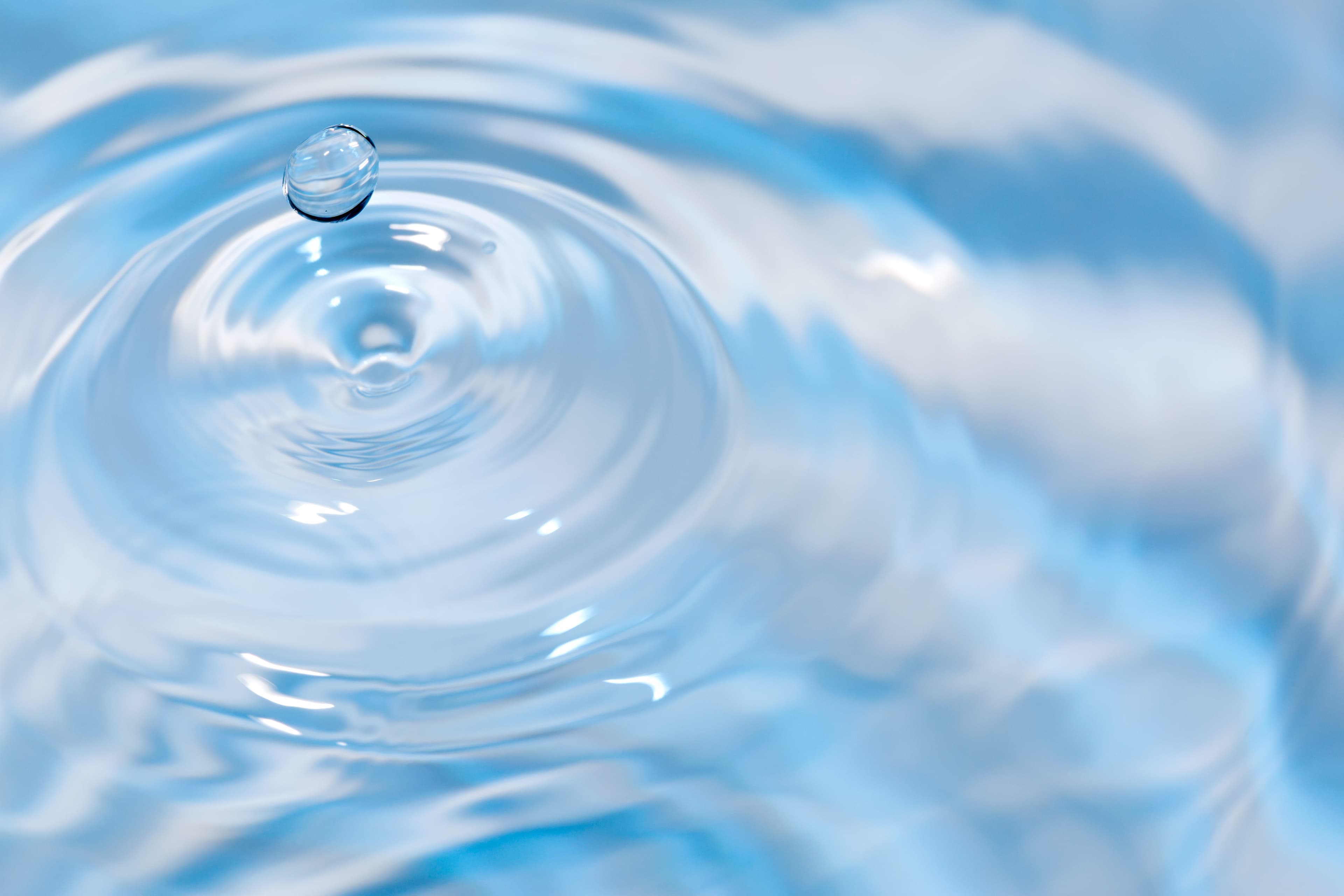 Wassertropfen zieht Kreise im klaren Wasser.