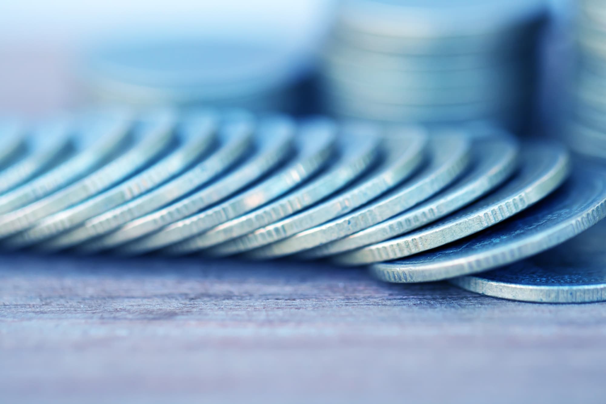 Münzen liegen aufgereiht auf einem Tisch.